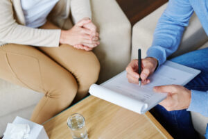 A woman working with her therapist about continued support with individual and group therapy sessions, as well as available support groups, after completing the PHP treatment programs for drug addiction