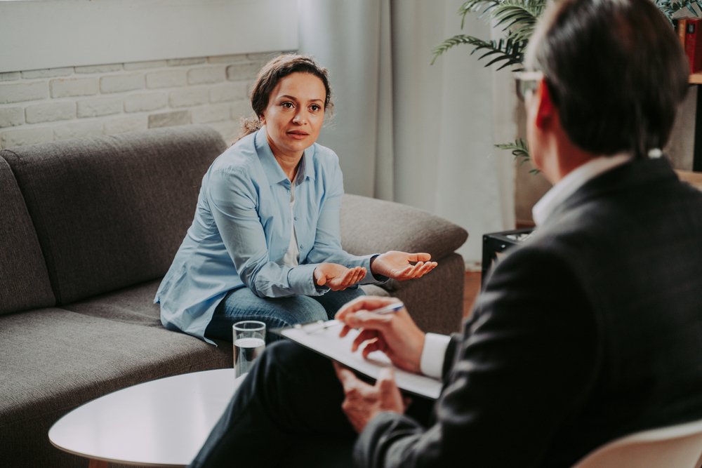 a woman speaking to a counselor about if her Multiplan mental health rehab insurance covers treatment